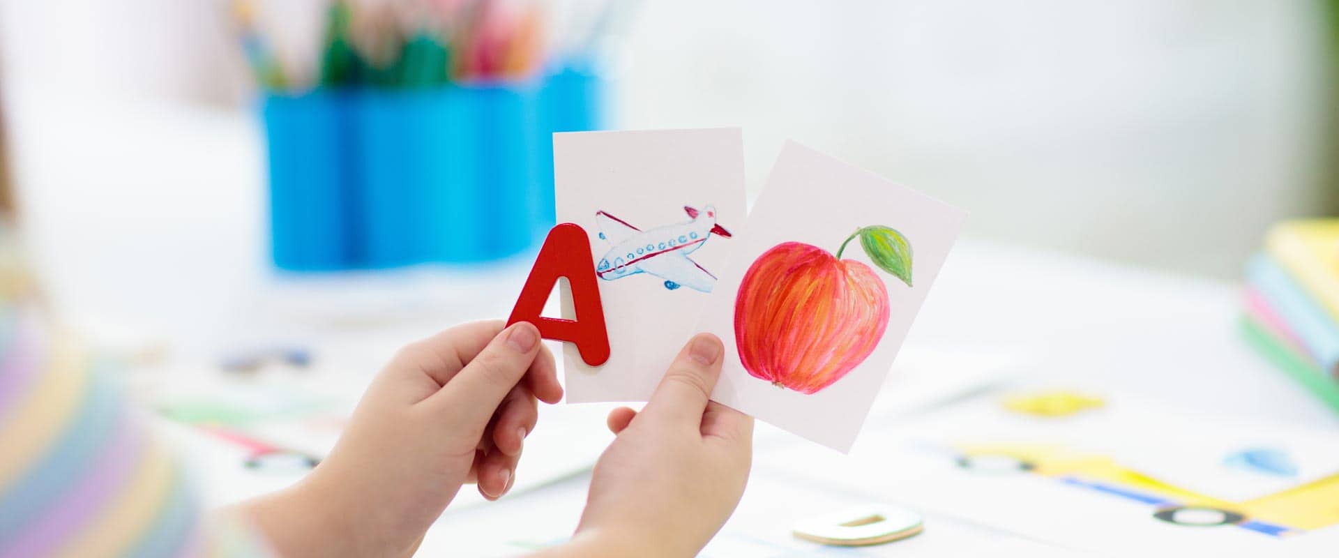 Kinderhände halten eine Zeichnung von einem Apfel